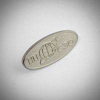 металлический серебристый овальный значок с логотипом